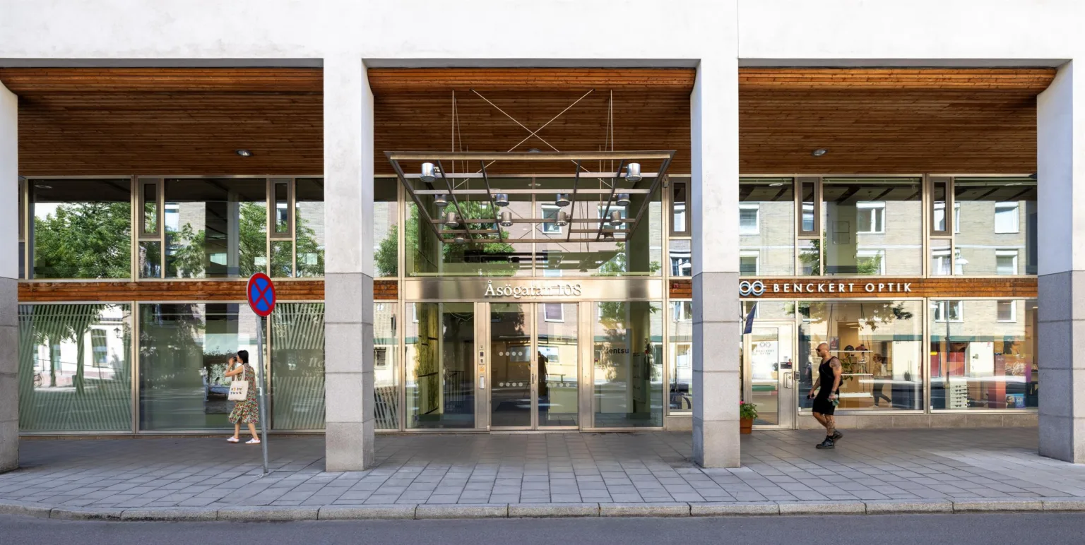 3. En modern byggnad med glasfasad och trädetaljer, reflekterande stadsmiljö i glaset.