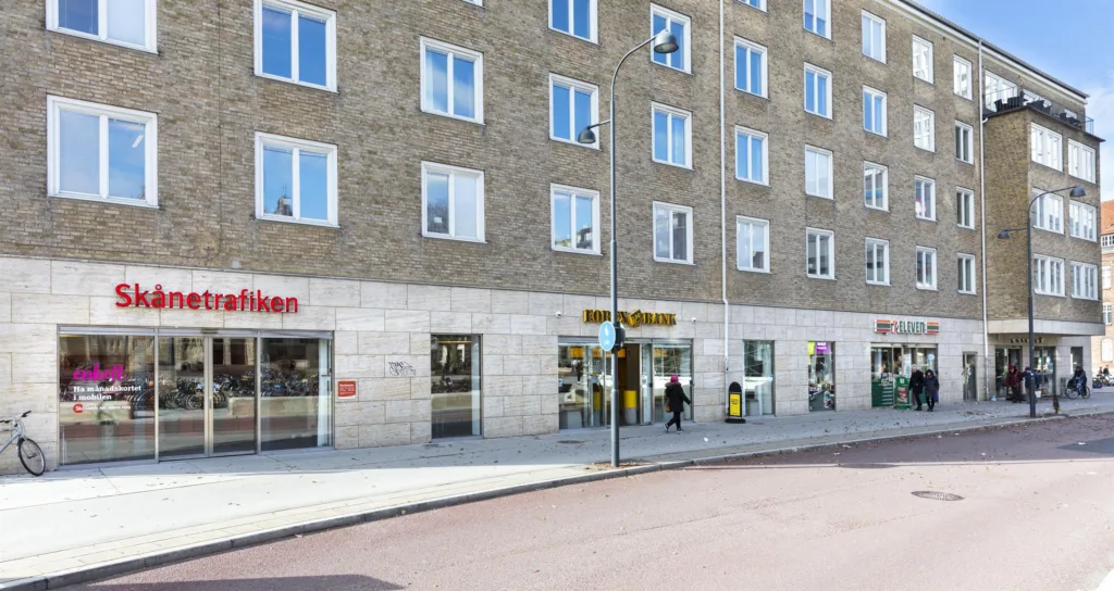 1. En byggnad med butiker på bottenvåningen, inklusive en skylt för "Hemköp".