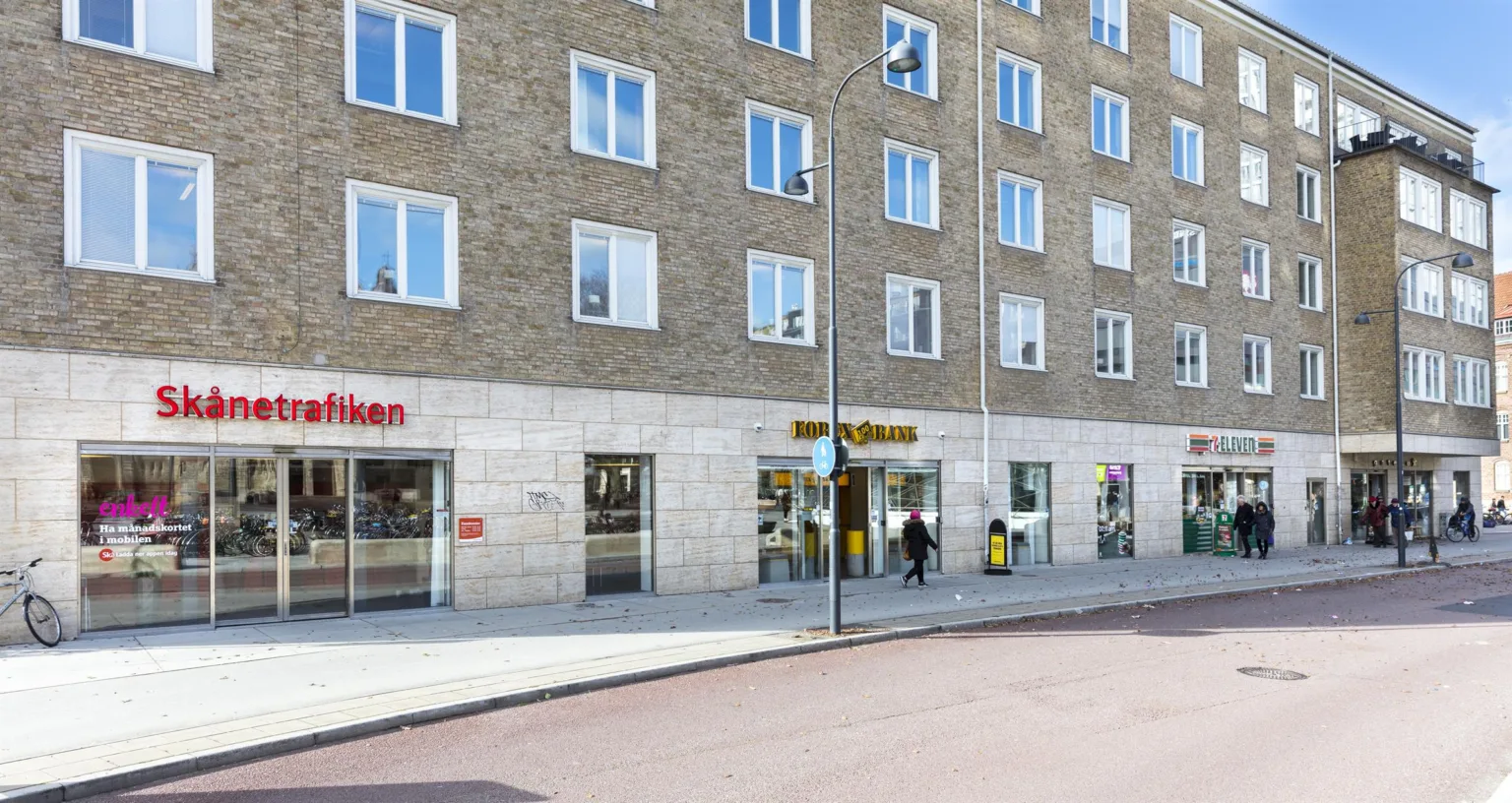 1. En byggnad med butiker på bottenvåningen, inklusive en skylt för "Hemköp".