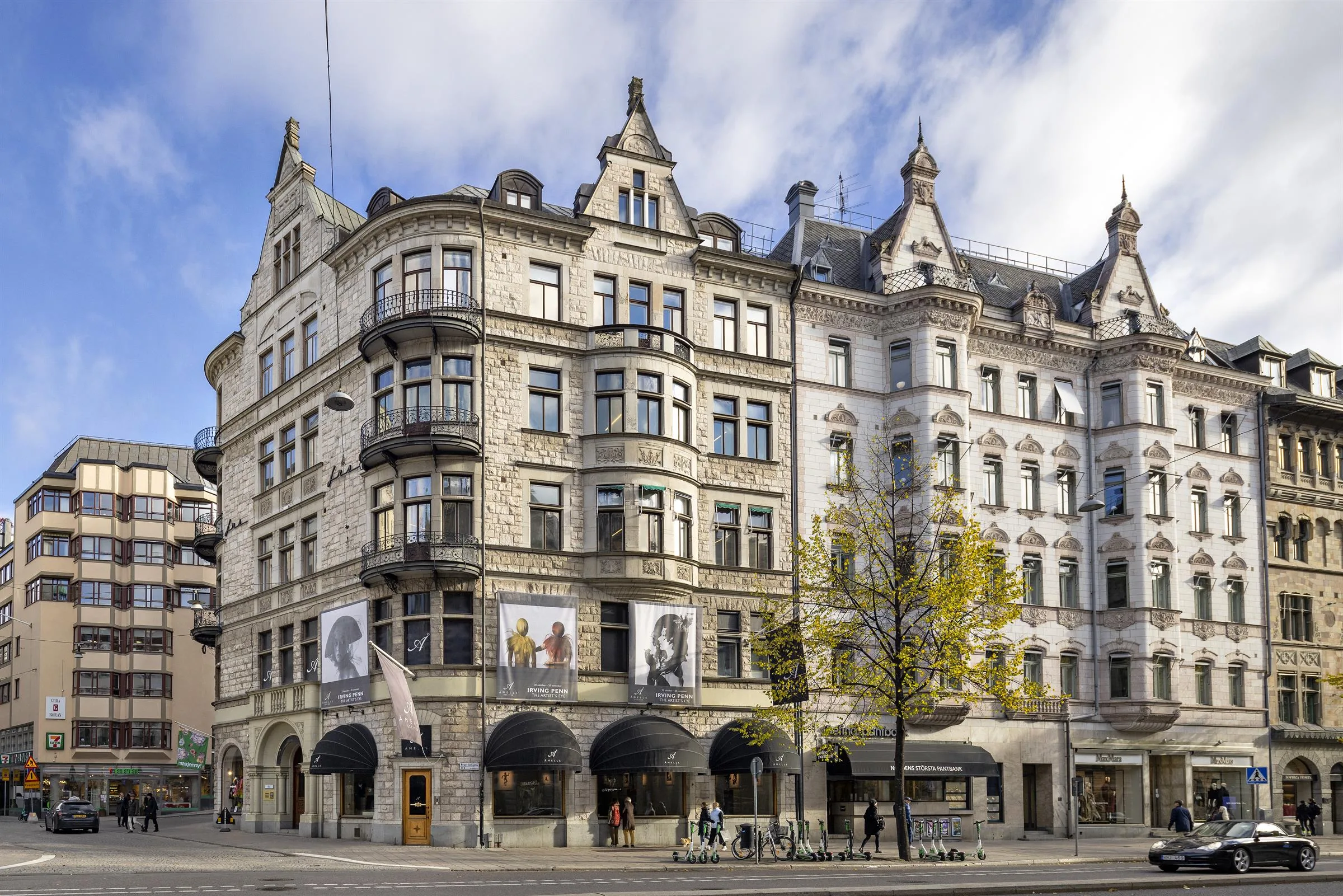 En klassisk byggnad med detaljrik arkitektur, valvbågar och affischer på fasaden.