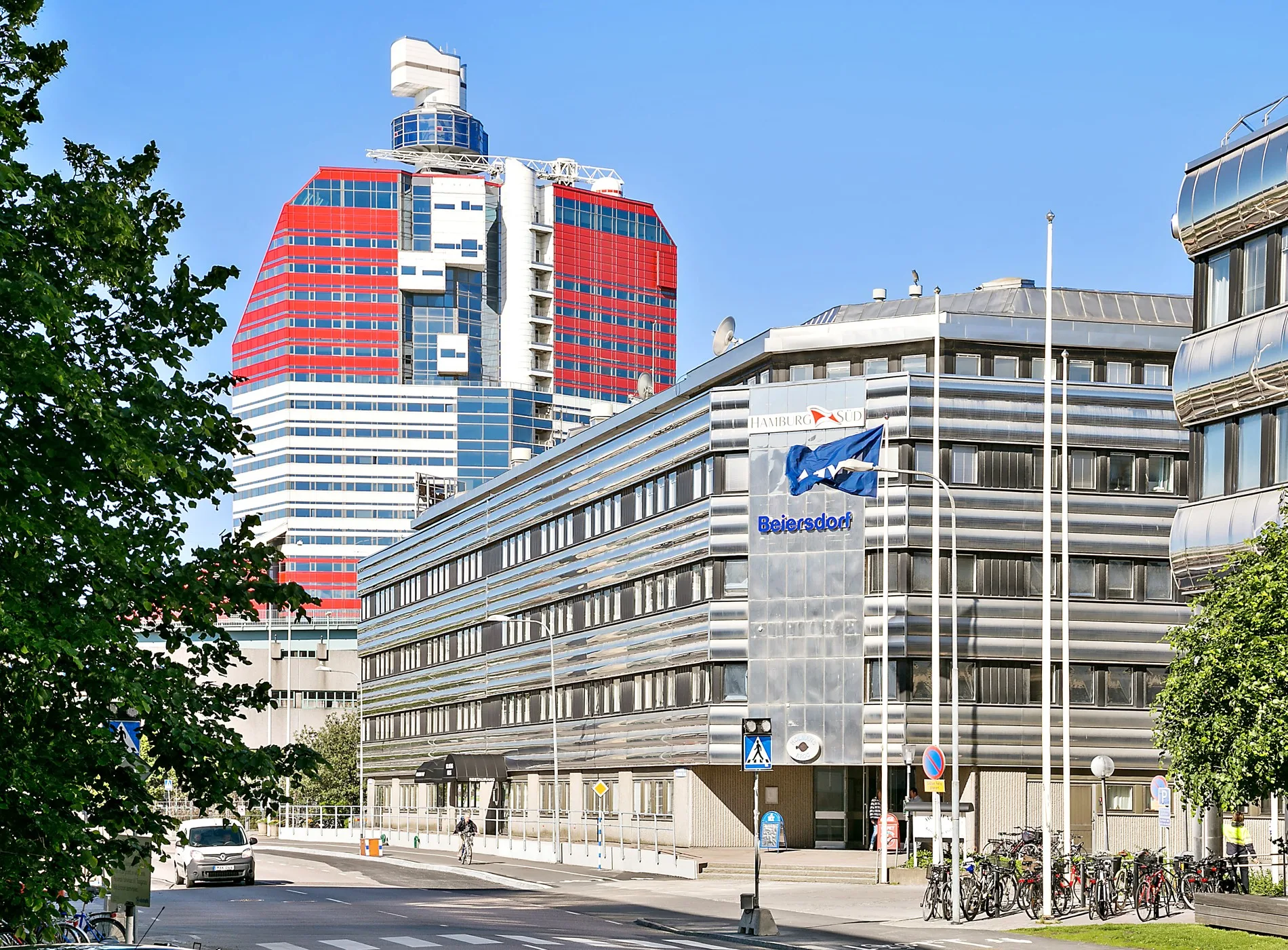 3. En gata med en modern byggnad i förgrunden och en färgglad, höghusliknande struktur i bakgrunden.