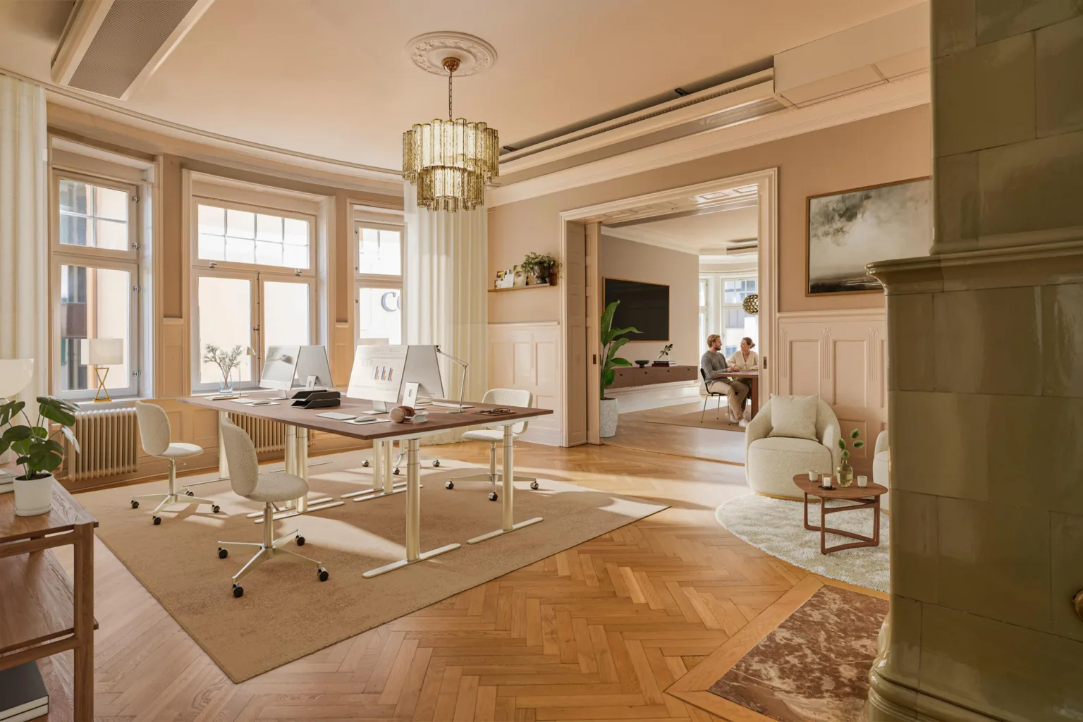 2. Arbetsrum med skrivbord, stolar och lampa, angränsande vardagsrum och stora fönster.