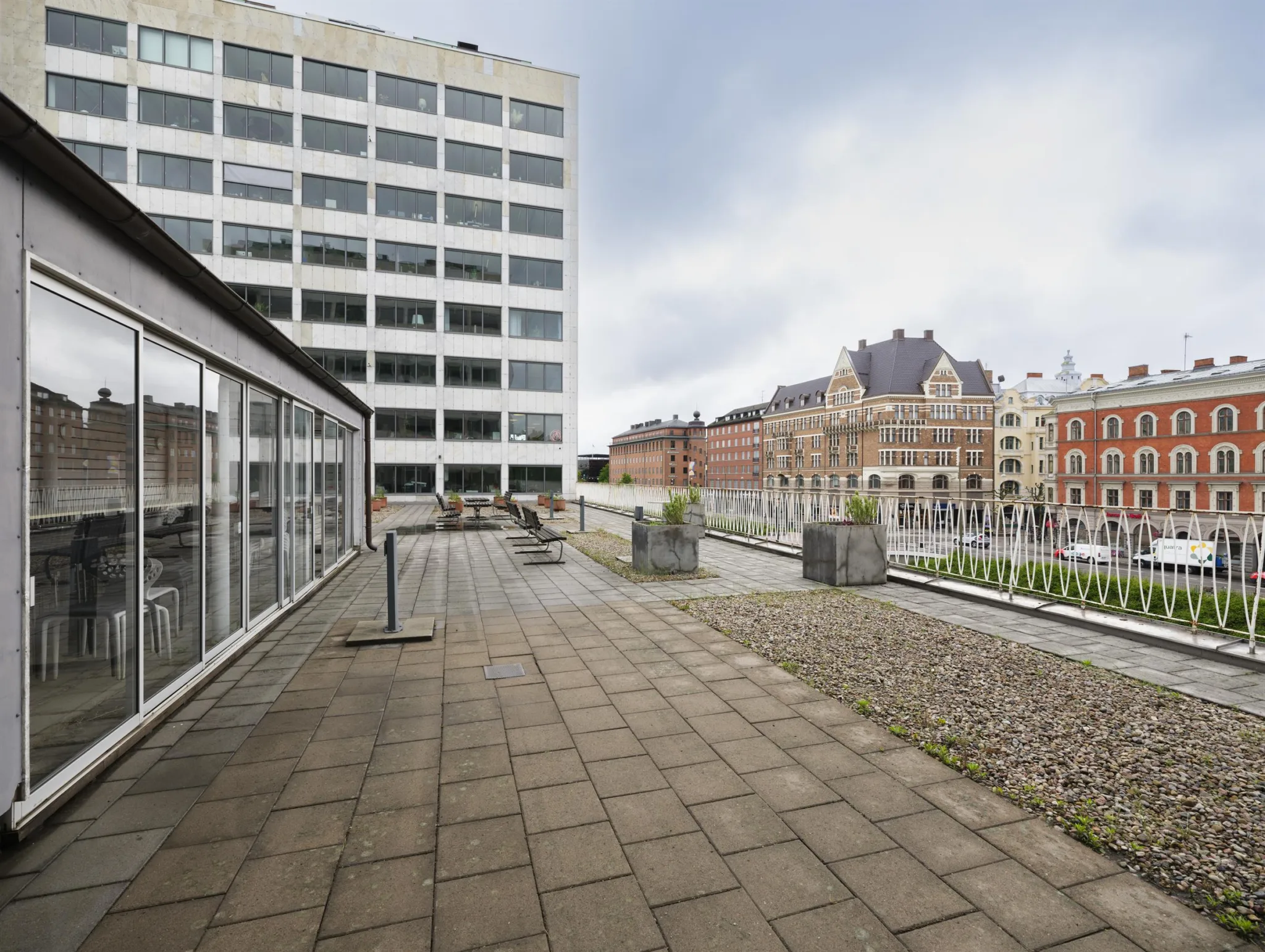5. Stor terrass med stenläggning, utsikt över en stadsmiljö med byggnader.